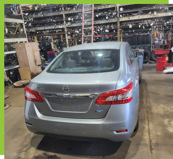 Silver car inside a parts warehouse.